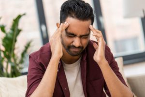 a man holding his head in pain