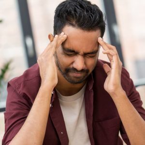 a man holding his head in pain