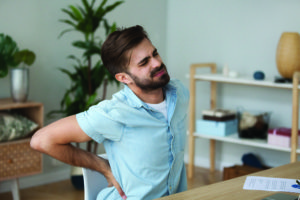 Tired man feeling pain in back suffering from lower backache