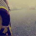 Close up of man wearing trainers running in a foggy street.