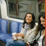 Two young women riding the train