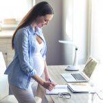Pregnant women temporarily working from writes down notes