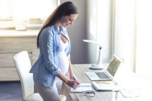Pregnant women temporarily working from writes down notes
