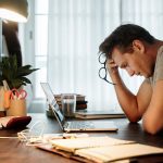 Man sat at desk looking stressed