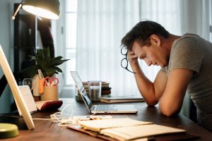 Man sat at desk looking stressed