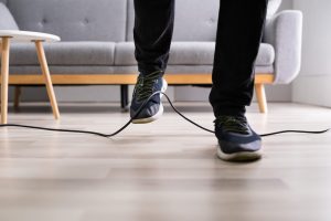 Person trying to step over an electrical cord without tripping