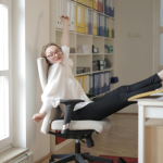 An office worker stretching her legs by propping them up on her desk.
