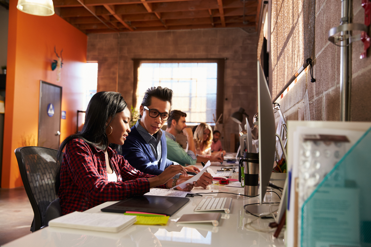 Team Of Designers Working At Desks In Modern Office