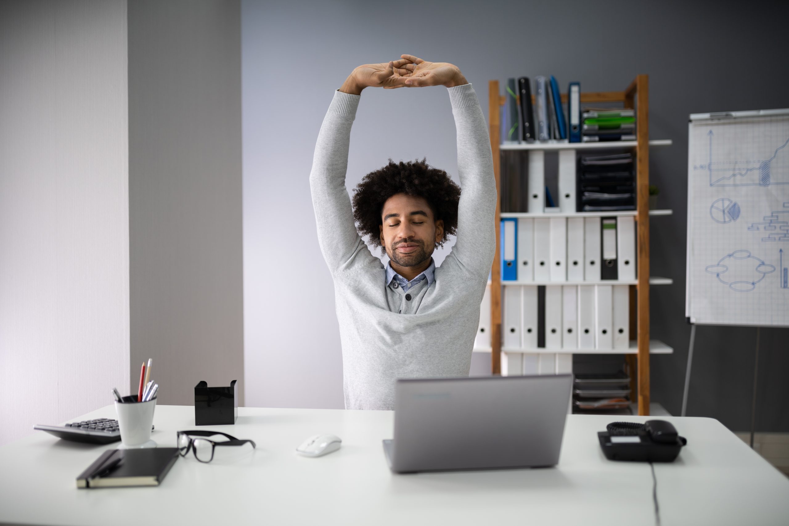 Man stretching at desk
