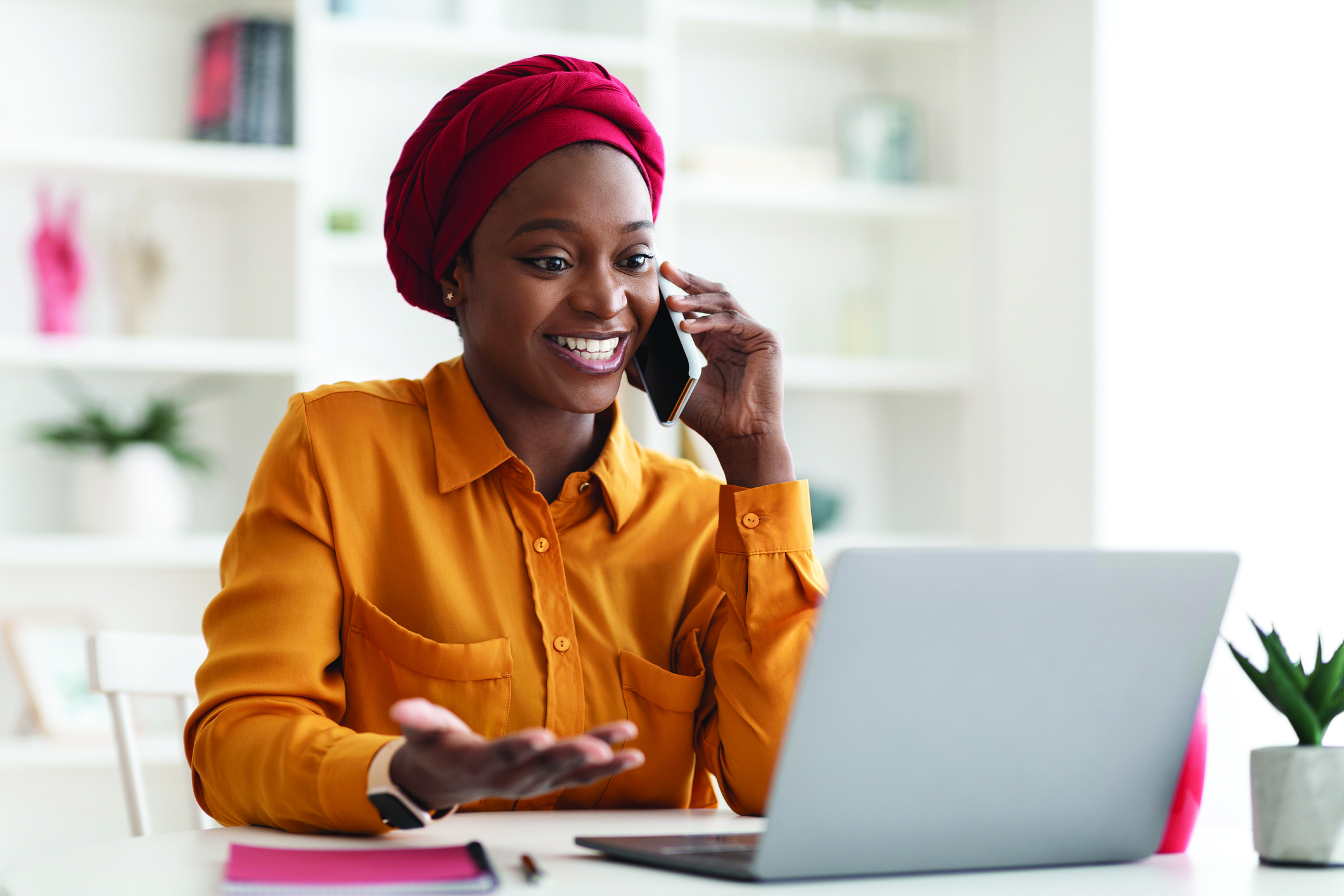 Positive muslim black lady working on laptop at office