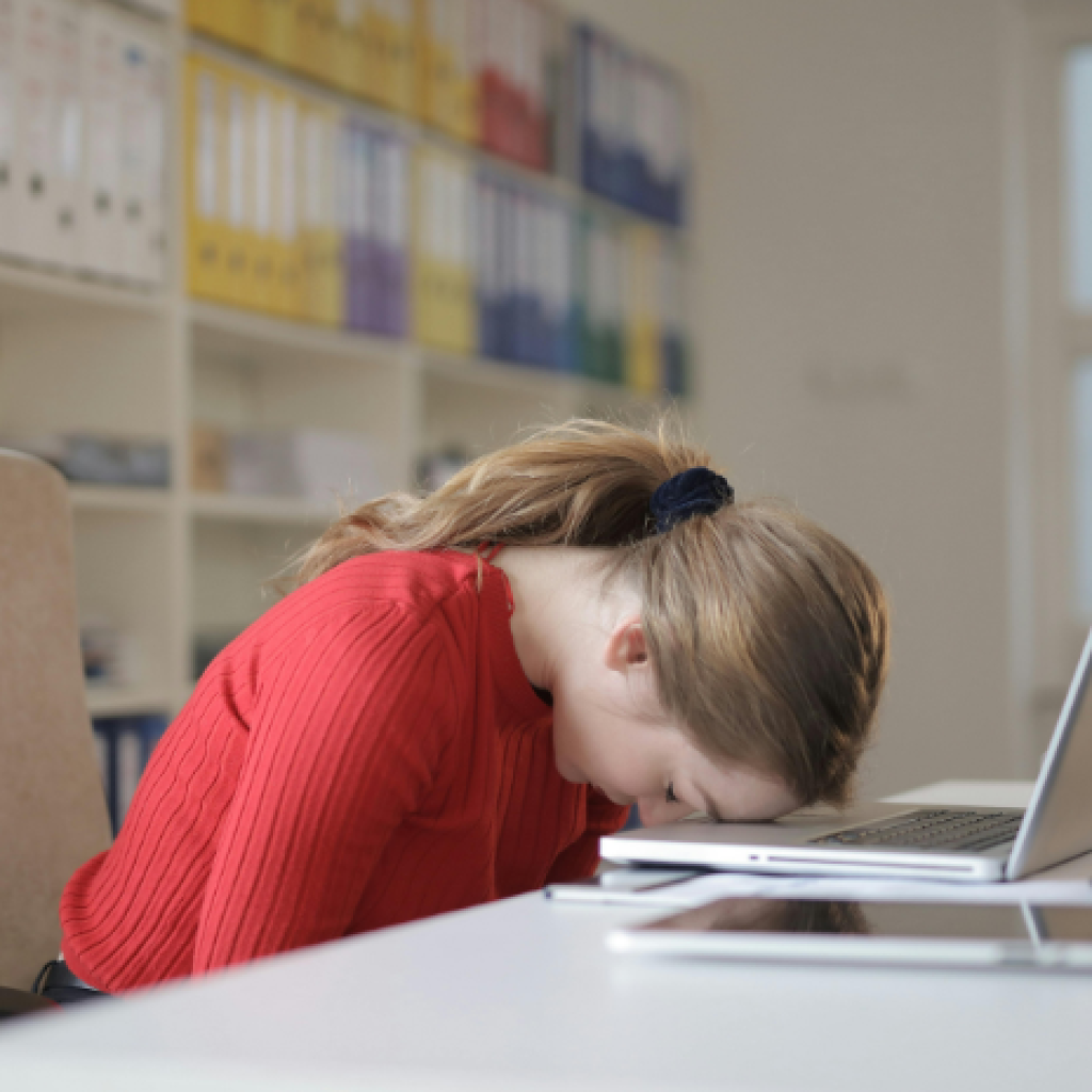 An office worker with her forehead to the desk.