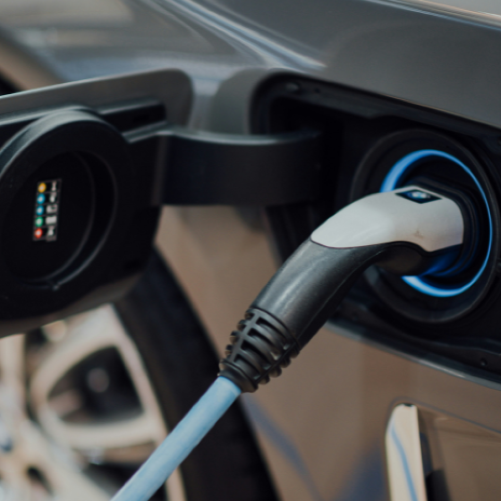 A close-up of an EV charging cable plugged into a electric car charging port.